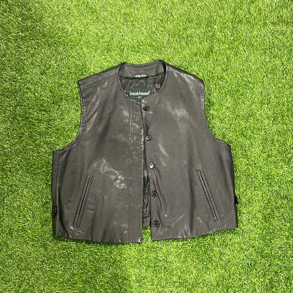 Ladies black leather vest with hidden buttons, pockets, & elastic back.